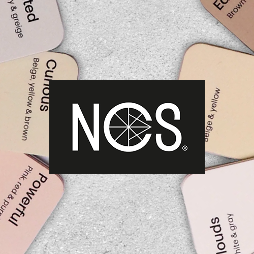 A set of fan-shaped color sample cards with abstract geometric designs in muted tones arranged around a central black square featuring the white NCS logo.