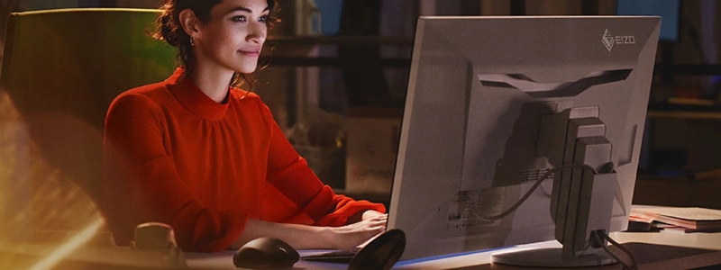 An image of a woman working on an EIZO FlexScan monitor.