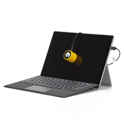 An image showing the Calibrite Display 123, a device for calibrating the colour on your monitor, hung by its cable over a laptop so that the sensor is against the screen for measuring the screen colour during calibration.